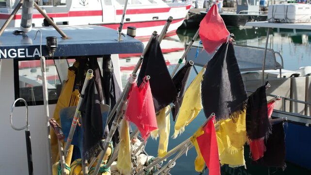 Saintes-Maries-de-la-Mer, Camargue, France. June 20, 2026. Colorful fishing marker flags and gear on a small fishing boat in the harbor. Small-scale fisheries and traditional Mediterranean fishing.