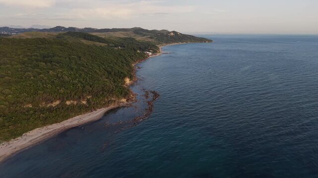 Overhead aerial view of a secluded beach, submerged rocks and forested coastline at Kepi i Rodonit, Albania.