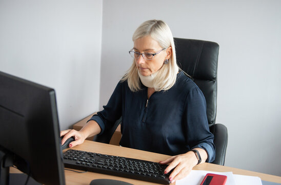 Office Worker Wearing Soft Cervical Neck Collar While Working