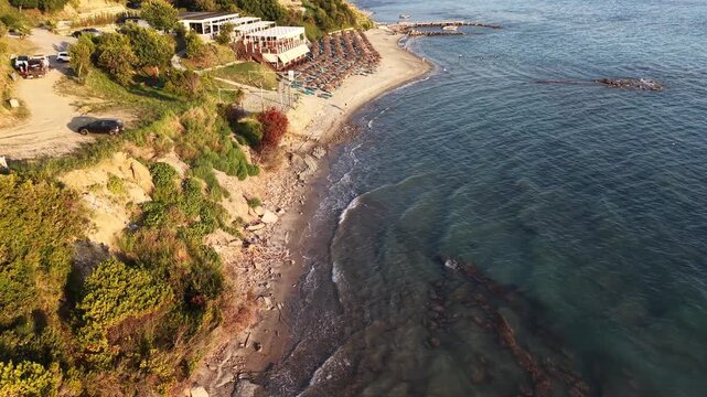 Overhead aerial view of a secluded beach, submerged rocks and forested coastline at Kepi i Rodonit, Albania.