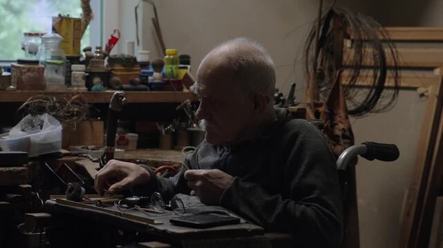 Elderly craftsman working in his old workshop, carefully restoring collectible Japanese bladed weapons