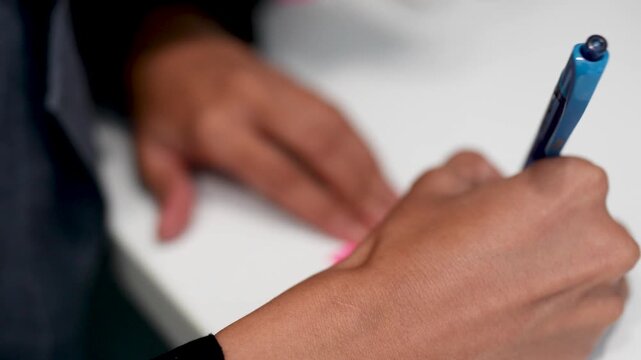 Female hands taking notes on paper in soft focus