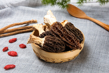 Fresh Morel Mushrooms In Woven Bamboo Basket With Wolfberry © ads