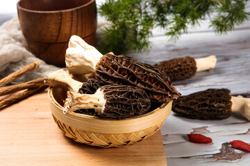 Fresh Morel Mushrooms In Woven Bamboo Basket With Wolfberry © ads