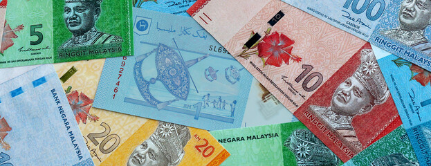 Malaysian ringgit money banknotes pile on table. Malaysia bills of MYR currency close up © Larysa