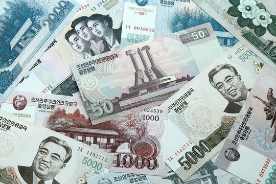 North Korean won money banknotes pile on table. North Korea bills of KPW currency close up
