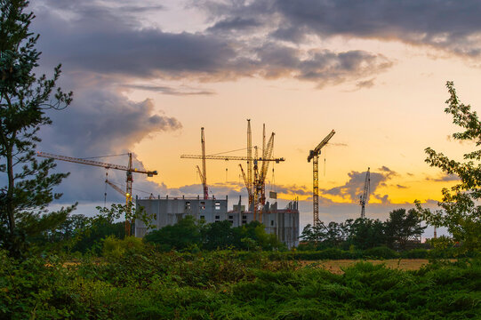 Eine Baustelle mit Kr&auml;nen bei Sonnenuntergang