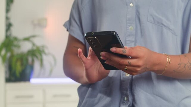 Focused Black Woman With Natural Hair Browsing Her Smartphone In A Modern Indoor Setting