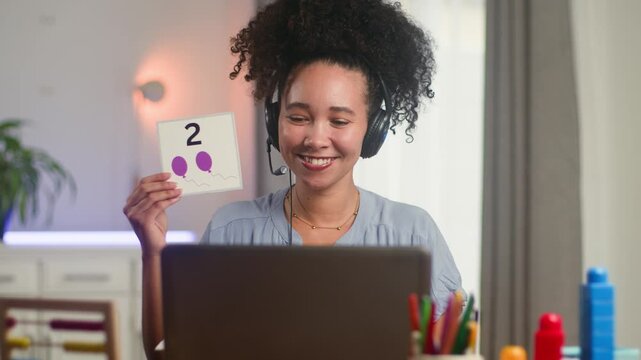 Smiling Black Woman with Natural Hair Teaches Math and English Online Using Flashcards for Primary Education