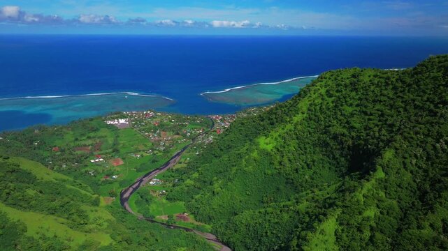 Aerial view sunny morning town of Teahupo'o village End of the Road Tahiti French Polynesia drone neighborhood buildings Teahupo'o wave lagoon surfing Passe Havea coral reef Vaiau River valley forward