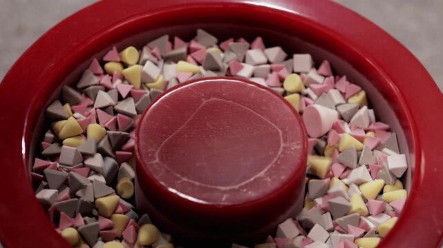 Vibrating polishing drum filled with plastic particles works in workshop closeup. Friction removes burrs scale oil achieving smooth at industrial exhibition