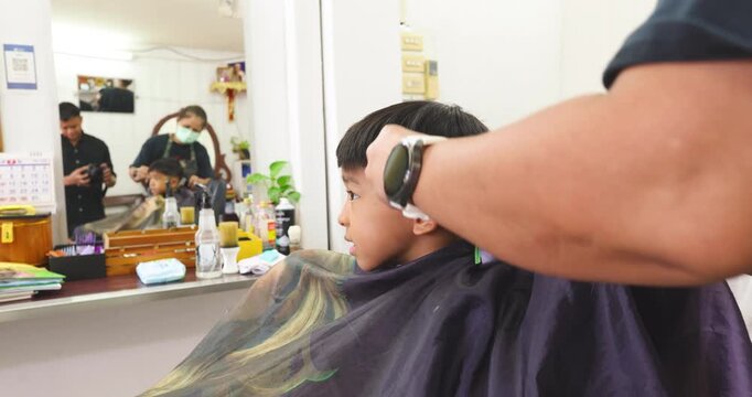 Little asian school boy hair cut in man barber shop beauty fashion