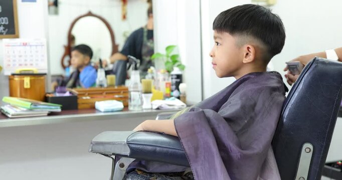 Little asian school boy hair cut in man barber shop beauty fashion
