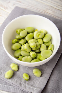 Fresh fava beans in a bowl on a grey napkin