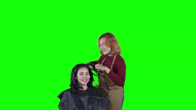 Female Hairstylist Styling Client's Hair with Round Brush Isolated Green Screen