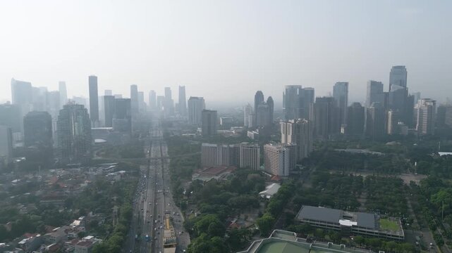Aerial View of Hazy Jakarta City Skyline and Highway Traffic