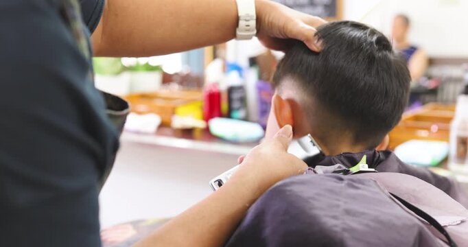Little asian school boy hair cut in man barber shop beauty fashion