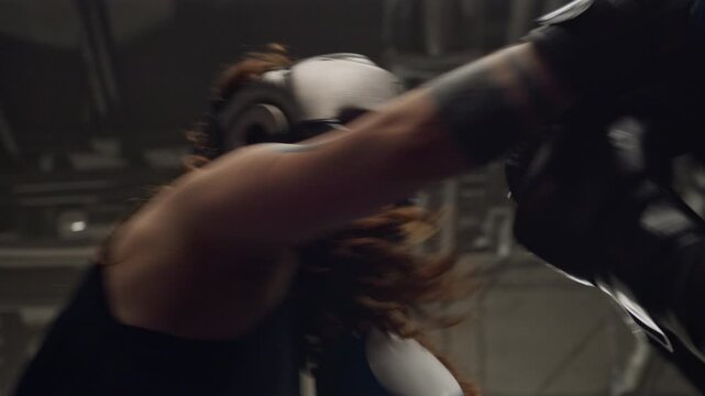 Two young Caucasian women sparring in boxing ring wearing protective headgear and gloves. Perfect for fitness brand commercials and women empowerment campaigns