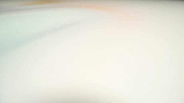 Abstract slow motion view of white surface with soft blurred orange and yellow color gradients for background