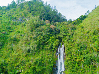 Aerial drone view of greenery hills with Situmurun Waterfall near Toba Lake at Lumban Juju in Toba, Sumatera Utara, Indonesia © MUAZ JAFFAR
