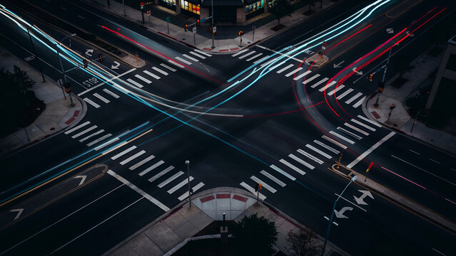 City intersection with light trails during nighttime long exposure abstract urban transport concept