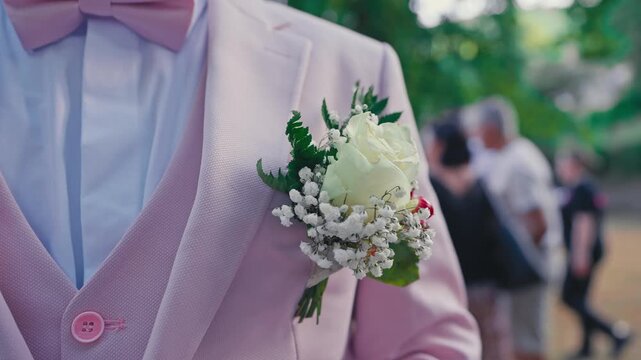 Close Up of Groom Boutonniere with White Rose and Baby's Breath