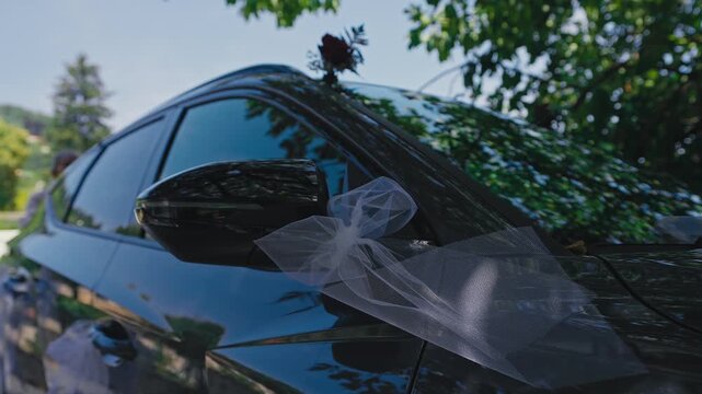 Close Up of Wedding Car Side Mirror Decorated with White Tulle Bow