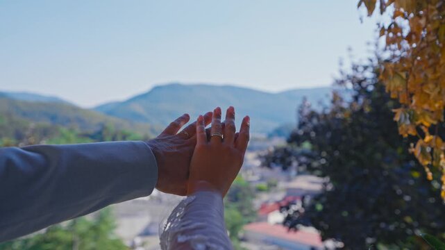 Newlywed Couple Showing Wedding Rings with Mountain Landscape Background