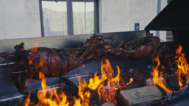 Whole Roasted Lamb Turning on Spit Over Open Fire