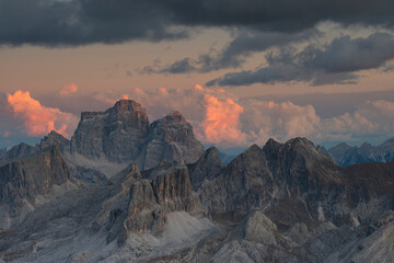 Majestic view of Dolomite mountain peaks illuminated by sunset light under a dramatic stormy sky. Ideal for travel and nature themes. © marcodenaro
