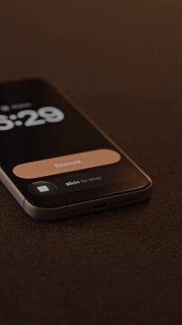 Hand Snoozing Alarm on Smartphone in Bed.
