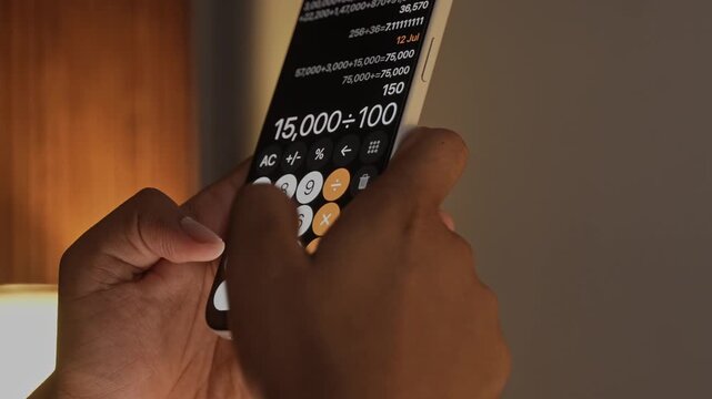 Hand Using Calculator App on Smartphone for Calculation.
