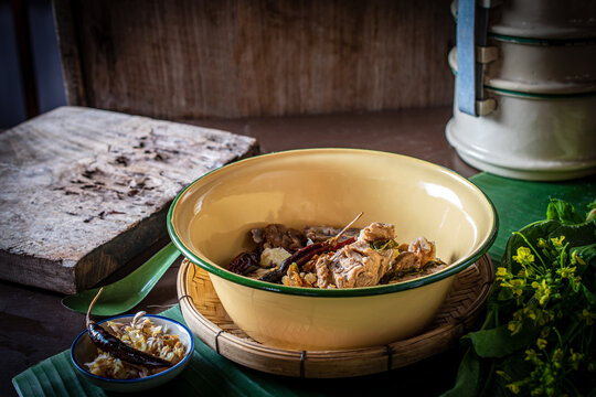 Traditional Northern Thai Jor Pak Kad soup with pork and mustard greens in a vintage enamel bowl on banana leaf. Authentic local dish with sour tamarind, herbs, and fried chili. 