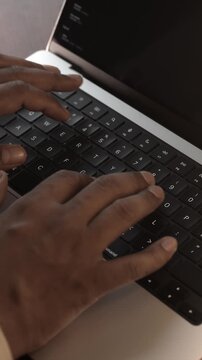 Hands Typing on Laptop Keyboard in Warm Cozy Lighted Room.
