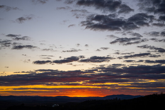Sunset glowing through silhouette tree branches and foliage in Ibitipoca landscape