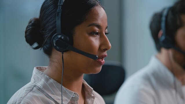 Arabian business woman customer support operator talking with headset in modern call center with multiracial team female helpline agent talk consultation assistance to clients in office callcenter