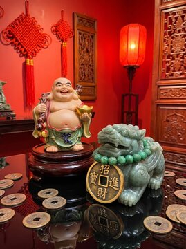 Charming laughing buddha and pixiu figurine displayed in a traditional asian decor setting