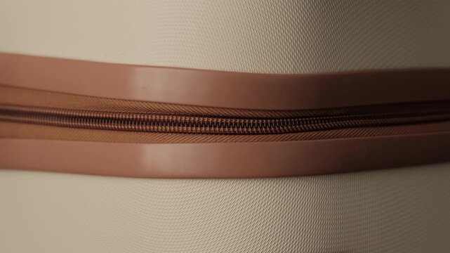 Closing suitcase zipper. Extreme close up of luggage being zipped before travel, relocation or departure, minimalist authentic lifestyle detail