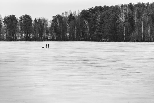 Minimalist Monochrome Landscape of Frozen Lake With Tiny Silhouettes of Fishermen