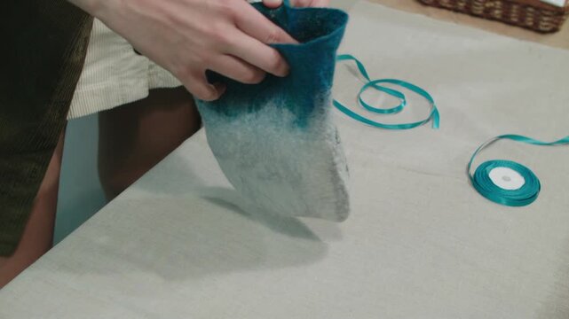 Packing homemade soap and ceramic plate in felted bag for gift or sale. Souvenir workshop. Hobbyshop.