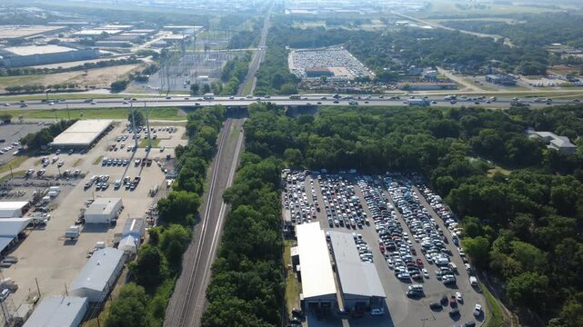 Heavy freight railway tracks cut through dense woodlands alongside commercial automotive yards mirroring regional transport grids. Active freight lines connect with logistics hubs in Irving, TX