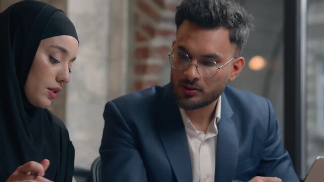 Business team Arabian Hindu Hispanic man woman with laptop talking discuss job multiracial businesswoman in hijab writing notes intern learning communicate with businessman leader boss CEO in office