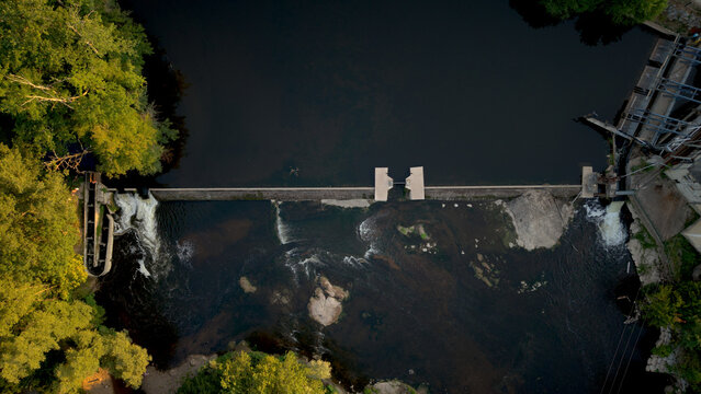 Aerial top view of a river weir and footbridge, drone photograph at dusk