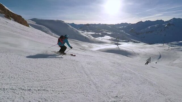 4k high resolution stock video, Skier Standing on Snow Covered Alpine Mountain Peak Overlooking Scenic Winter Landscape Under Clear Blue Sky Adventure Travel and Extreme Skiing in the Alps