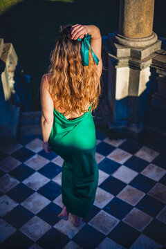 High angle view from behind of woman in emerald green dress at historic palace