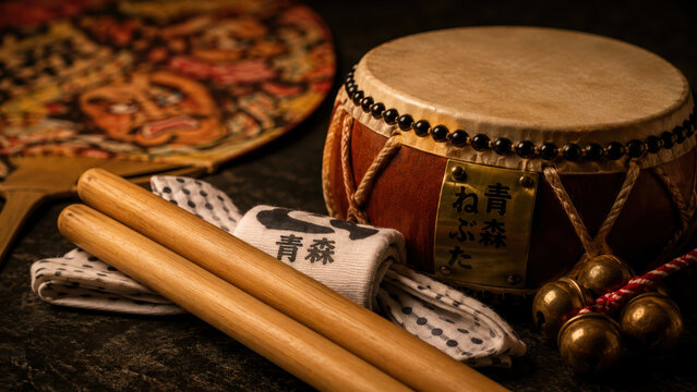 Traditional nebuta festival drum, wooden bachi sticks, patterned tenugui cloth, brass suzu bells, painted uchiwa fan, warm lantern light, taiko percussion, japanese matsuri procession craft