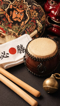 Taiko drum with bachi sticks, tengu mask, warrior fan, festival towel, bronze bell, lantern craft, japanese matsuri instruments, traditional parade energy, washi artistry, theatrical folklore