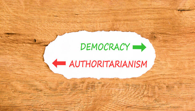 Democracy or authoritarianism words symbol. Concept words Democracy Authoritarianism on beautiful white paper. Beautiful wooden background. Business democracy authoritarianism concept. Copy space