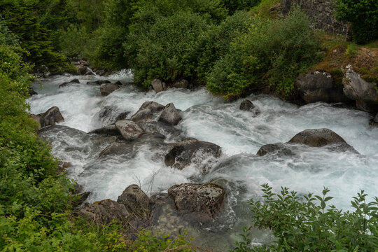 Vertical close-up landscape of a dynamic powerful rushing mountain river torrent with boulders