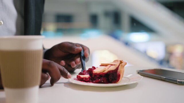 Close up male hands of unrecognizable African American business man eat slice of pie cake at table in cafe bakery unknown ethnic businessman visitor eat dessert in cafeteria enjoying breakfast dinner